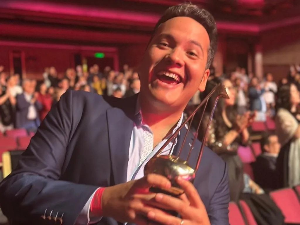 Gilberto Daza, sonriente, posa con su premio ARPA